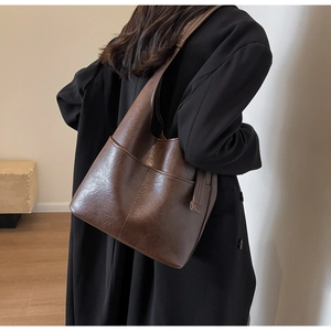 Detailansicht der großen braunen Leder-Tragetasche mit verstellbarem Riemen am Model