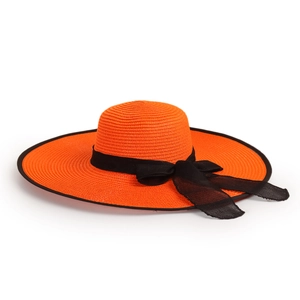 Detail of a bright orange straw sun hat with black contrast trim and a mesh bow