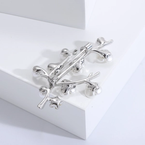 Detailed back view of silver shell plum blossom brooch with white pearl accents