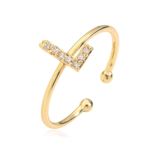 Detailed view of an adjustable gold letter T ring with shimmering cubic zirconia inlay