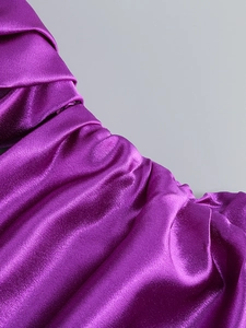 Detailed macro view of the shiny purple satin fabric with horizontal ruched texture