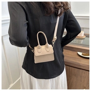 Detail der beigen Mini-Umhängetasche mit goldener Hardware und verstellbarem PU-Lederriemen