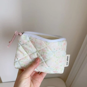 Detailed macro view of quilted floral pouch with simple wish label and pink zipper puller