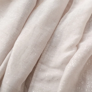 Detailed close-up of light pink cotton linen scarf featuring silver glitter and sheer texture