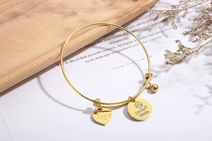 Close-up of golden adjustable wire bracelet with engraved Love You Grandma heart charms