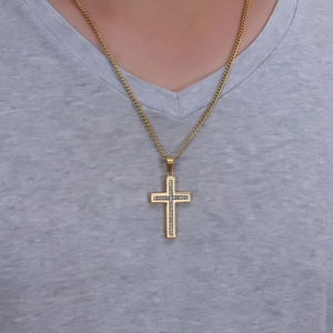 Dettaglio della collana con croce in acciaio dorato e diamanti indossata da un modello