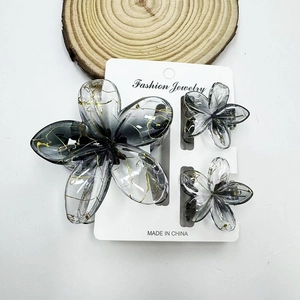 Makroaufnahme von 3-teiligem Blumen-Haarklammer-Set mit gebürsteter Textur und Goldverlauf