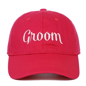 Close-up of white Groom embroidery on red cotton baseball cap with high-quality stitching