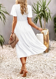 Detail of white midi dress featuring elastic shirred back and short ruffle sleeves