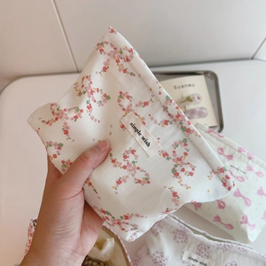 Close-up of floral makeup bag with simple wish label and smooth zipper closure