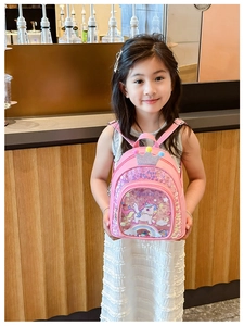 Pink unicorn school bag with sequins and crown decoration shown by a young girl