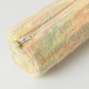 Détail macro de la trousse en maille arc-en-ciel avec texture pelucheuse et zip blanc