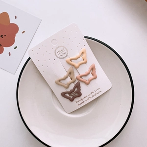 Set of 4 butterfly hair clips in matte milk tea colors on a paper display card