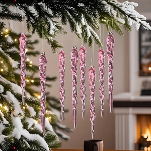 Pink spiral icicle ornaments hanging on snow-covered Christmas tree branches in warm indoor setting