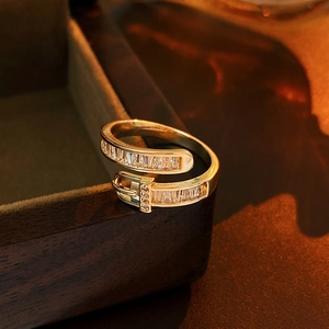 Detailed view of gold belt buckle ring with rectangular cubic zirconia on box edge