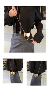 Detailed view of mini heart-shaped crossbody bag with gold geometric facets and chain