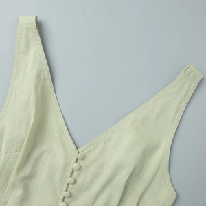 Detailed macro view of mint green cotton vest with fabric covered buttons and V-neckline