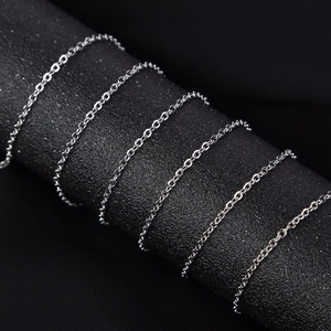 Polished silver stainless steel cross chain wrapped on a dark textured display cylinder