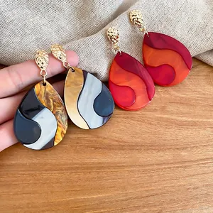 Retro teardrop earrings with tortoise shell resin patterns and gold textured metal studs