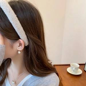 Close-up of elegant plush headband paired with pearl jewelry for a soft aesthetic look