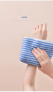 Exfoliating bath towel with blue stripes showing deep cleaning and skin scrubbing effect