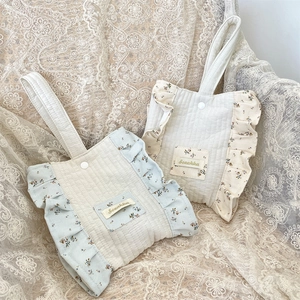 Detailed view of floral quilted handbags with ruffled edges and white button closure