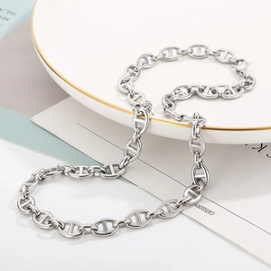 Minimalist silver stainless steel pig nose anchor chain necklace on a ceramic plate
