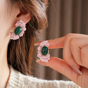 Detail of vintage pink flower earrings with green oval stone and golden metal edge