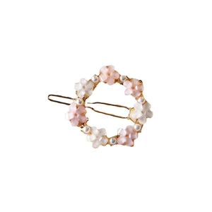 Golden metal floral hair clip with pink pearls and rhinestones on white background