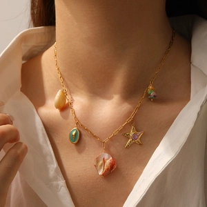 Détail du collier doré avec étoile de mer, coquillage et perles colorées sur modèle
