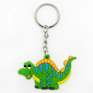 Cute green PVC dinosaur keychain with orange fins and blue stripes on a silver metal ring