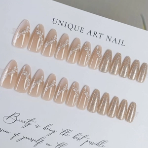 Nude gradient press-on nails with white hand-painted flowers and champagne gold glitter