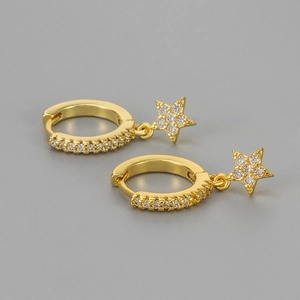 Detail of gold huggie hoop earrings with sparkling star charms and pavé zircon stones