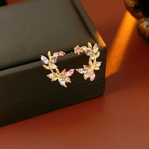 Detail of vintage branch earrings with colorful crystals on a black jewelry box