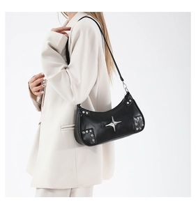 Detail of black leather shoulder bag featuring silver star studs and adjustable strap on model