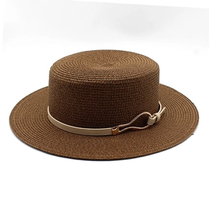 Detail of the brown boater straw hat with beige decorative band and gold metal buckle