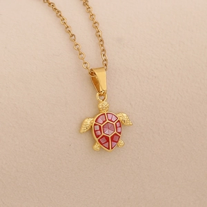 Macro view of gold tortoise pendant with red shell texture on stainless steel chain