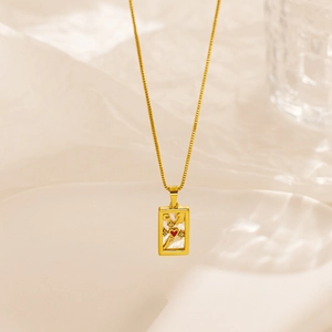 Detail of a vintage gold tarot pendant necklace with mother of pearl and a red heart icon