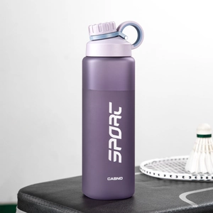 Close-up of purple frosted sports water bottle on a leather bag with badminton gear
