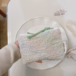 Vista ravvicinata della mini borsa in tweed arcobaleno con zip e etichetta in tessuto