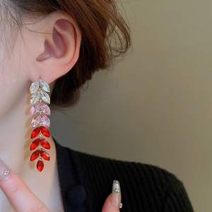 Detail of gradient leaf tassel earrings with sparkling crystals and gold plating