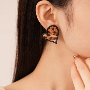 Gros plan de boucles d'oreilles cœur léopard sur mannequin au style rétro élégant