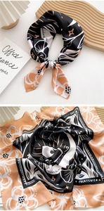 Detail of floral silk scarf with artistic patterns on a wooden tray with greeting card