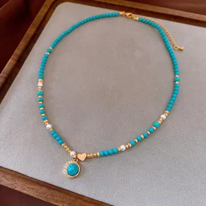 18K gold plated turquoise and pearl heart necklace with zircon pendant on wood tray