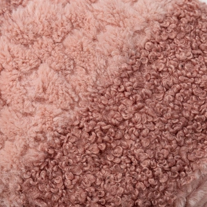 Macro detail of plush faux fur fabric showing soft pink-brown curly texture and warmth