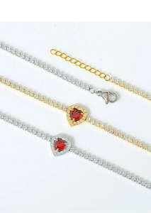 Macro shot of titanium steel heart necklaces with red zircon stones on white background