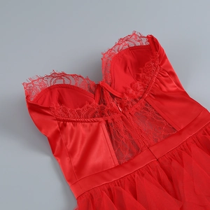 Détail de la texture en dentelle rouge et du patchwork en satin brillant sur la robe