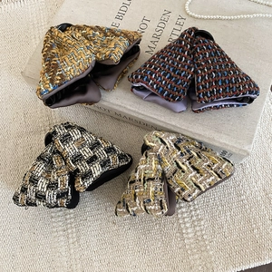Détail de quatre barrettes à cheveux en tweed aux couleurs variées et tissage fin