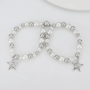 Detalle de pulseras de perlas con dije de estrella y cierre magnético de corazón