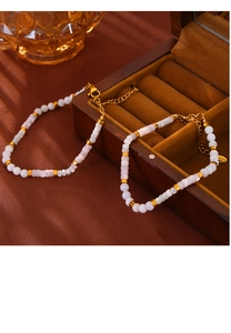 Close-up of beaded necklace with white pink shell beads and gold stainless steel clasp